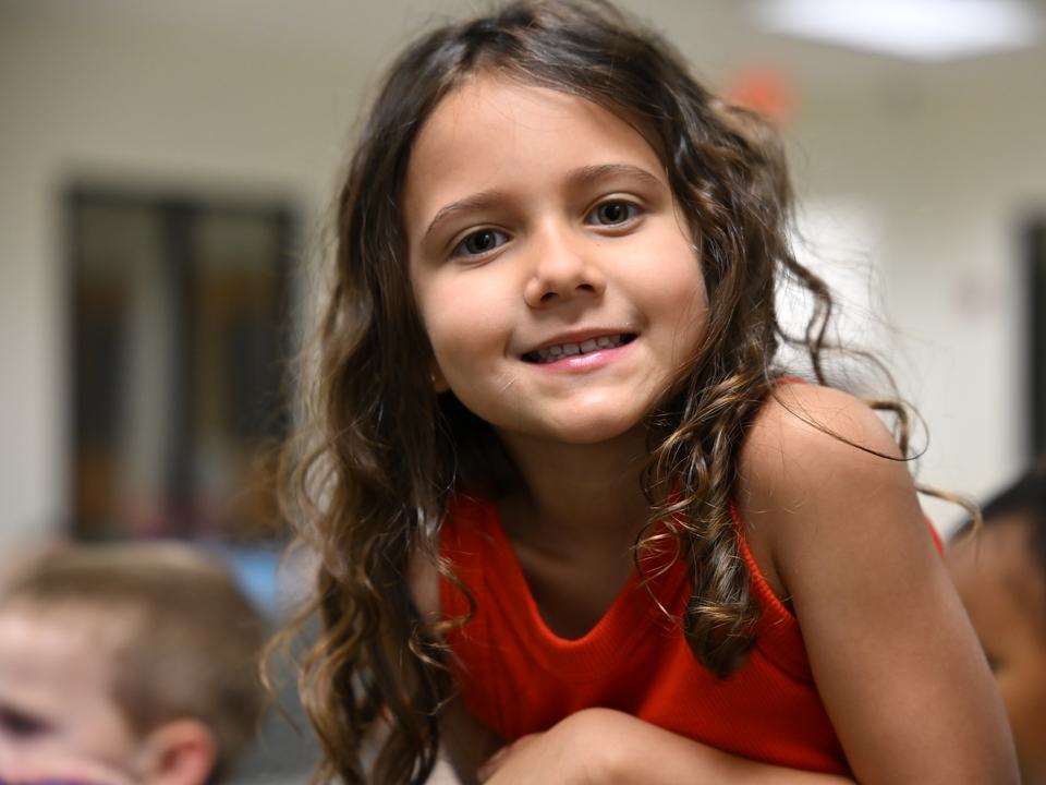 A smiling girl with long curly hair